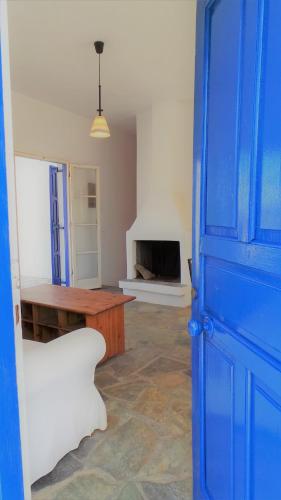 a blue door in a room with a table and a desk at Vitali Beach Houses in Andros