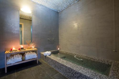 La salle de bains est pourvue d'une baignoire et d'un miroir. dans l'établissement Ilion Spa Hotel, à Loutra Edipsou