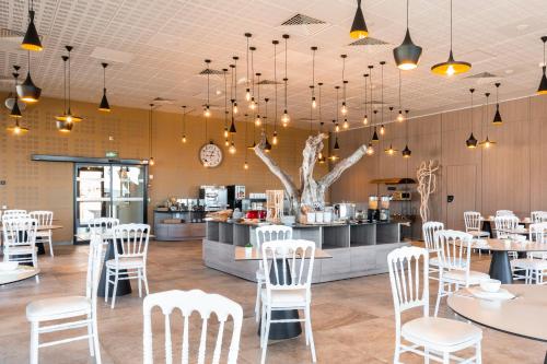een restaurant met witte stoelen en tafels en een bar bij Domaine des Gueules Cassees in La Valette-du-Var