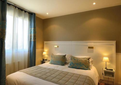 a bedroom with a bed with two pillows and a window at Castel Clara Thalasso & Spa in Bangor