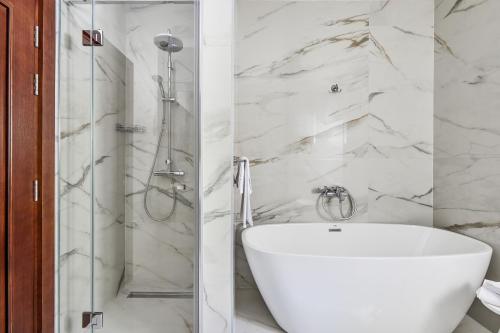 a bathroom with a shower and a white bath tub at Three Dots by Todorovic Family in Kotor