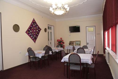 a dining room with tables and chairs and a kite on the wall at World Guest House in Samarkand