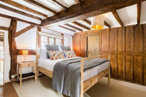 ein Schlafzimmer mit einem Bett in einem Zimmer mit Holzwänden in der Unterkunft 3 MASONS COURT The Oldest House in Stratford Upon Avon, Warwickshire. in Stratford-upon-Avon