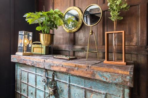 an old chest with two mirrors and a plant on it at 3 MASONS COURT The Oldest House in Stratford Upon Avon, Warwickshire. in Stratford-upon-Avon