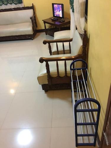 a room with two chairs and a laptop on a table at Pines Mansion II in Butuan
