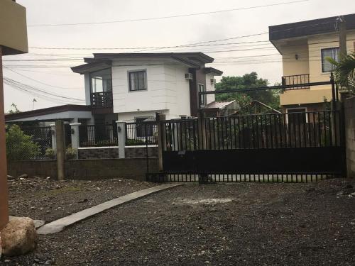 a fence in front of a white house at Pines Mansion II in Butuan