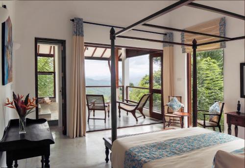 a bedroom with a bed and a balcony at Rosyth Estate House in Pinnawala