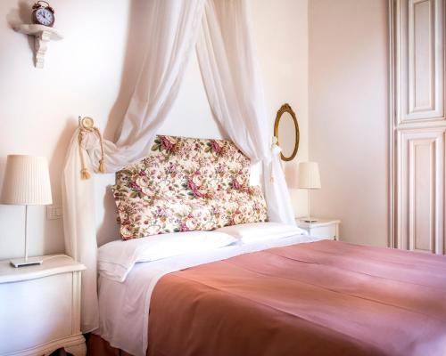 a bedroom with a bed with a flower pillow on it at Agriturismo Pieve Sprenna in Buonconvento