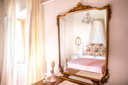 a bedroom with a mirror on the wall at Agriturismo Pieve Sprenna in Buonconvento