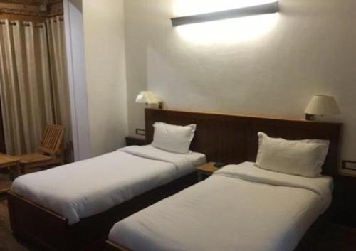 a hotel room with two beds with white sheets at Himalayan Retreat-Karzoo in Leh