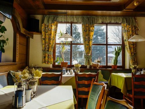 um restaurante com mesas e cadeiras e uma janela em Hotel Lenauhof em Bad Birnbach
