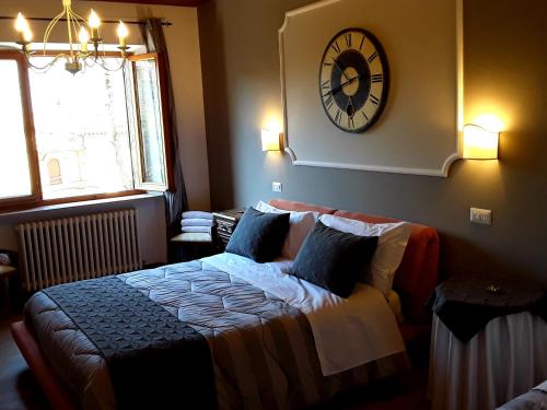 a bedroom with a bed and a clock on the wall at Suite Umberto I in Assisi