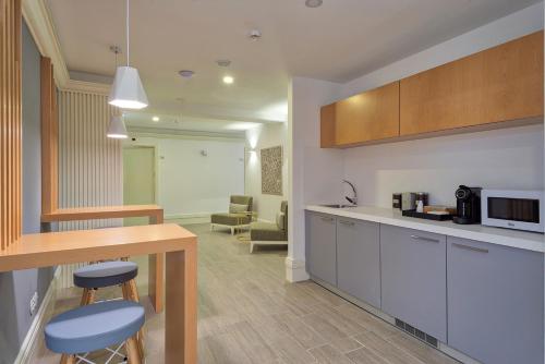 a kitchen with a counter and some chairs in a room at Alojamento da Vila in Valença
