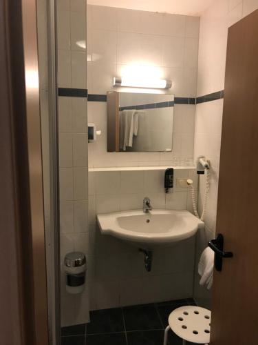 a bathroom with a sink and a mirror at Hotel Gasthof Grüner Wald in Hofheim am Taunus