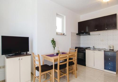 eine Küche mit einem Tisch mit Stühlen und einem TV in der Unterkunft Apartments Ljuba - in center & close to the beach in Duba