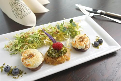 a white plate with food on a table at Farmer Hotel Basedow in Basedow