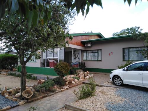a white car parked in front of a house at Xenia Bed & Breakfast in Windhoek