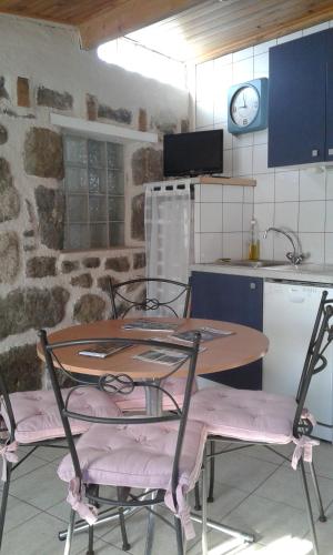 a kitchen with a table and chairs in a kitchen at La maison D'Orée in Polignac
