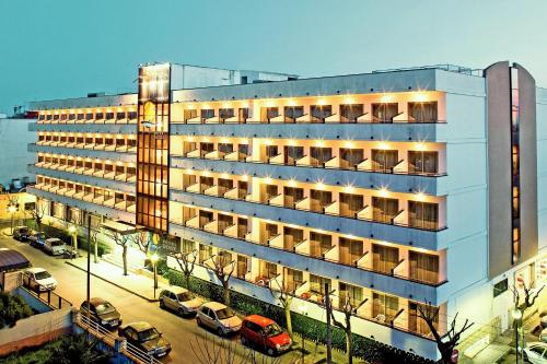 a large building with cars parked in a parking lot at Hotel Mariant in S'Illot
