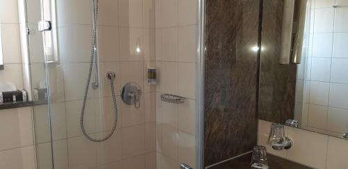 a bathroom with a shower with a glass door at Hotel Rauch in Ettringen