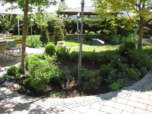 a garden with flowers and a lamp post at Hotel Rauch in Ettringen