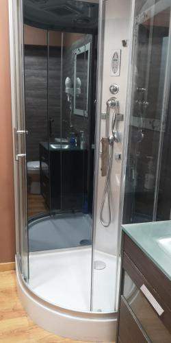 a glass shower in a bathroom with a sink at Pensión La Estación in Sarria