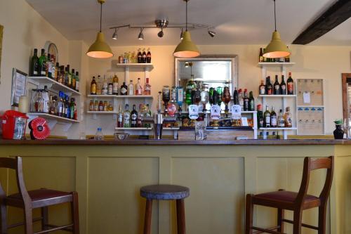 a bar with two chairs and a counter with bottles at AUBERGE DU NOYER in Londigny