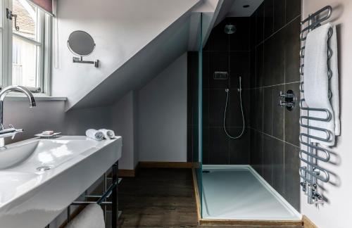 La salle de bains est pourvue d'une douche avec une porte en verre. dans l'établissement Crown and Castle, à Orford