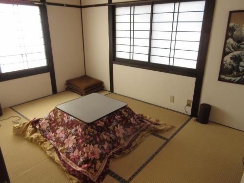 a room with a bed on the floor with two windows at Shinshu Wakaho Gibier B&B in Nagano