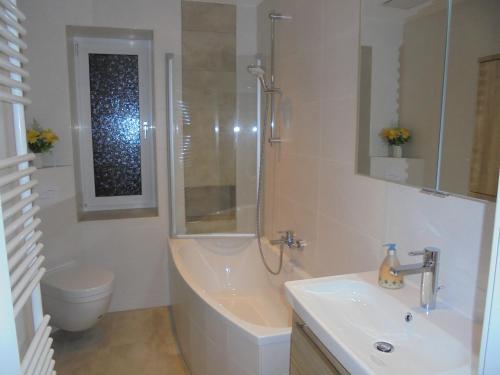 a bathroom with a tub and a sink and a toilet at Ferienwohnung am Hafen in Lübbenau