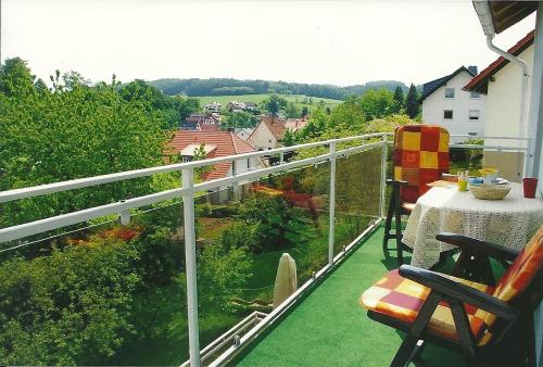a balcony with a table and a view of a garden at Ferienwohnung Dommes in Fuhrbach