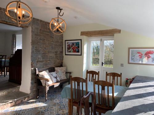 a dining room and living room with a table and chairs at Pontyclerc Farm House Bed and Breakfast in Ammanford