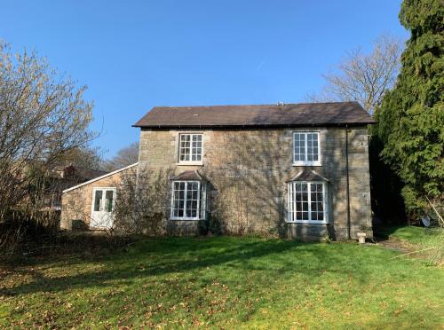 an old stone house on a grass field at Pontyclerc Farm House Bed and Breakfast in Ammanford