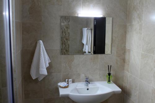 y baño con lavabo, espejo y ducha. en Sea & Hill Guest Houses хотелски тип, en Lozenets