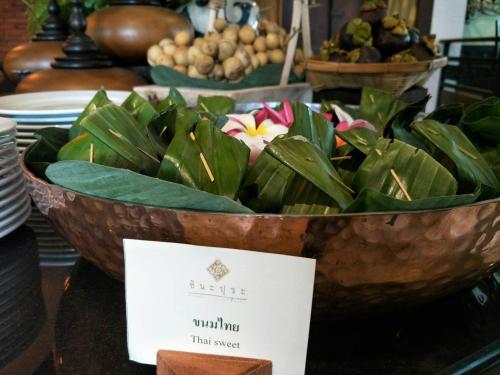 a bowl of food on a table with a sign in it at Shinnabhura Historic Boutique Hotel in Phitsanulok
