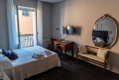 a bedroom with a bed and a mirror and a chair at Al Sale in Cagliari