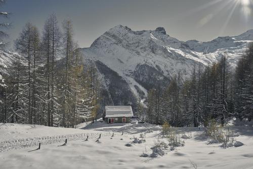 a small cabin in the snow with a mountain at Hotel Marmotte in Saas-Fee