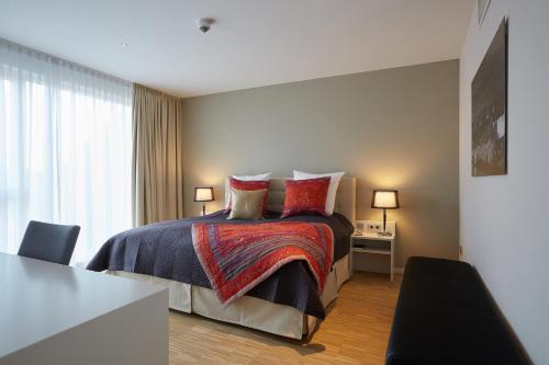 a bedroom with a bed with pillows and a table at Privathotel alte mühle Wolfsburg-Weyhausen in Wolfsburg