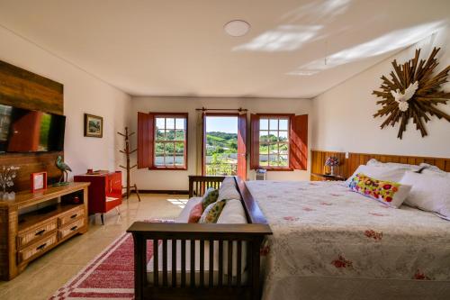 a bedroom with a large bed and a couch at Templo do Sol Acomodações in Prados