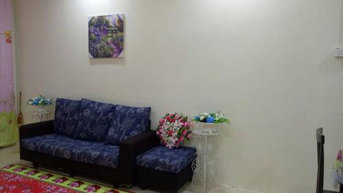 a living room with a purple couch and a table at HOMEMuslim GAMBANG in Kampong Pohoi