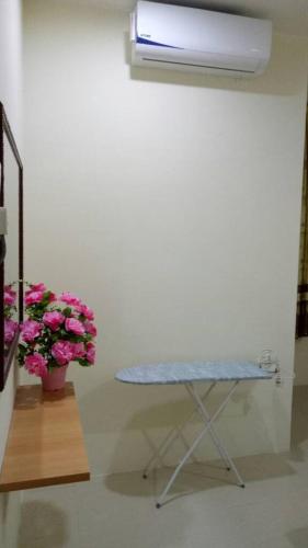 a table in a room with pink flowers and a plant at HOMEMuslim GAMBANG in Kampong Pohoi