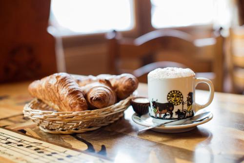 a table with a basket of croissants and a cup of coffee at Café Tivoli in Châtel-Saint-Denis