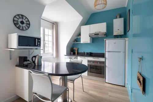 a kitchen with a table and a refrigerator at L'Anémone in Saint Malo