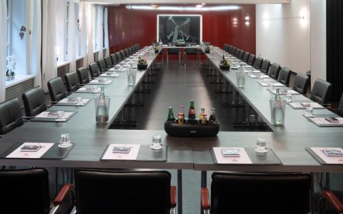 a large conference room with a long table with chairs at Privathotel alte mühle Wolfsburg-Weyhausen in Wolfsburg