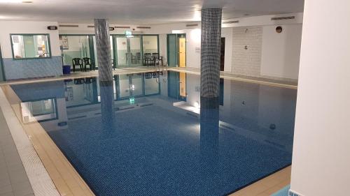 a large swimming pool with a blue tile floor at Pier Head Hotel Spa & Leisure in Mullaghmore