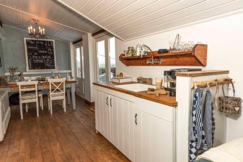 a kitchen with a counter and a table in it at B&B Bed en Omelet in Wagenberg