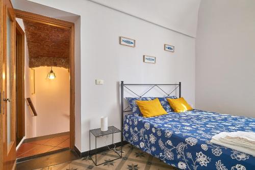 a bedroom with a bed with blue and yellow pillows at ACASADIGIULY in Ceriale