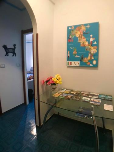 a room with a glass table with a painting on the wall at Appartamento del Golf - Secured Parking - in Rapallo