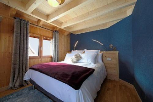 ein Schlafzimmer mit einem Bett und einer blauen Wand in der Unterkunft Gîte du Bief de la Chaille in Les Rousses