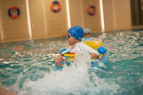 twee kinderen in het water in een zwembad bij Ramada Plaza Optics Valley Hotel Wuhan (Best of Ramada Worldwide) in Wuhan